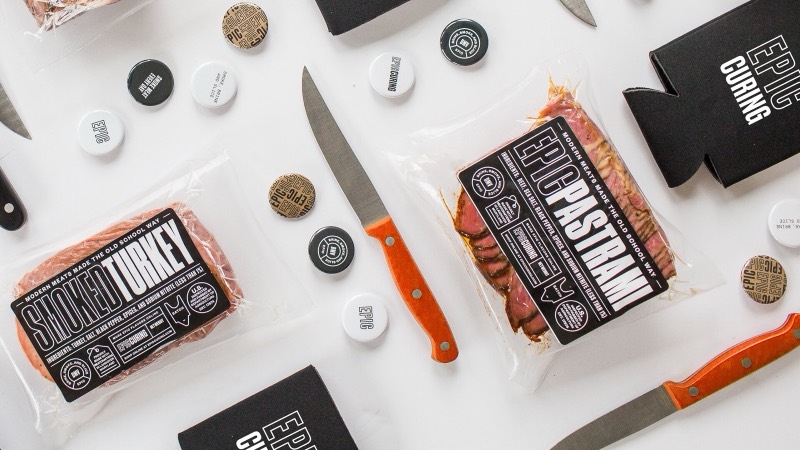 Epic Curing product line flatlay: labeled packs, knives, and brand tags on white