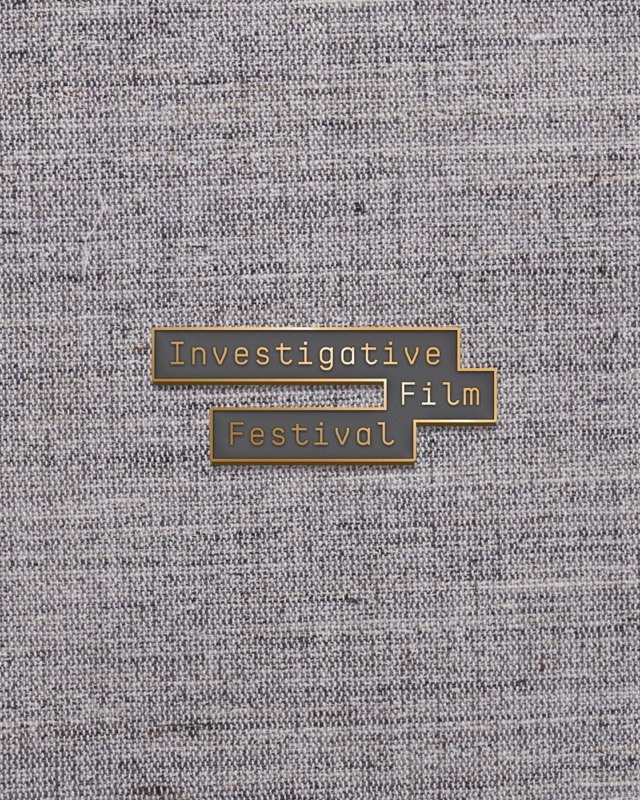 An enamel pin reading Investigative Film Festival on tweed
