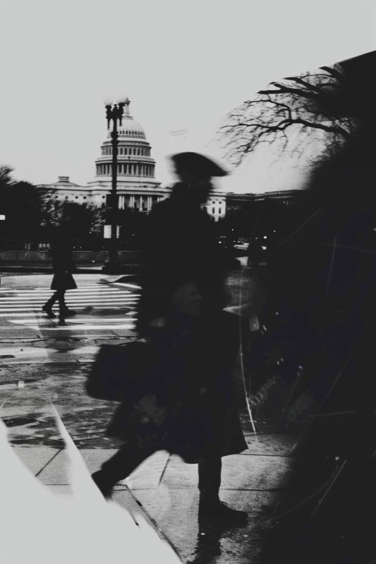 Study: a figure in a hat crossing the plaza in front of the Capitol