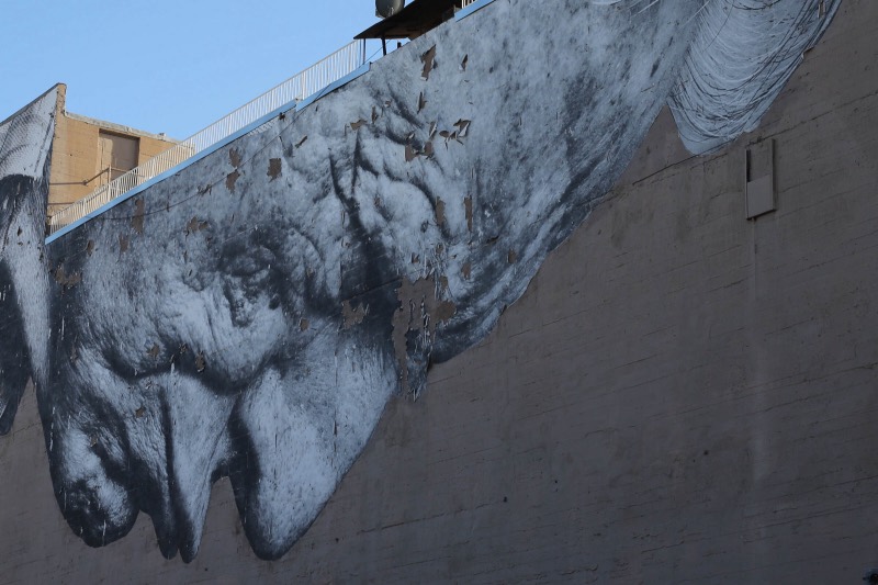 Weathered concrete wall with a pasted figure