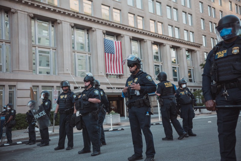 Children at the front of a Black Lives Matter march carrying a red banner, 2020